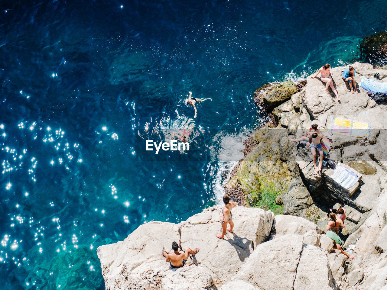 High angle view of people on rock over sea