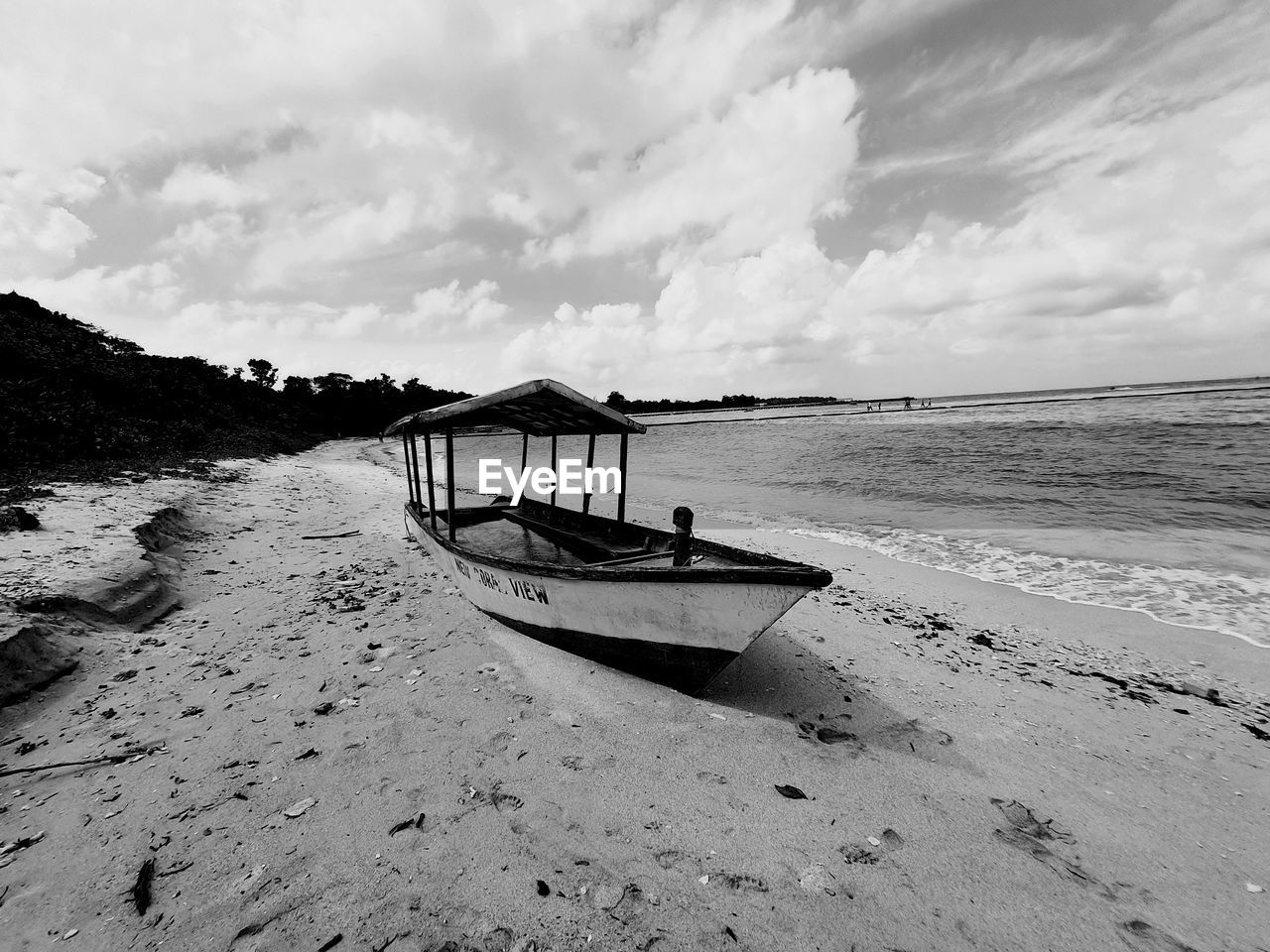 water, beach, land, sky, shore, sea, sand, black and white, cloud, nautical vessel, nature, coast, scenics - nature, monochrome photography, beauty in nature, monochrome, transportation, wave, tranquility, ocean, mode of transportation, tranquil scene, vehicle, travel, boat, day, holiday, outdoors, non-urban scene, moored, horizon, no people, travel destinations, vacation, trip, bay, coastline, horizon over water, body of water, idyllic, environment, tourism