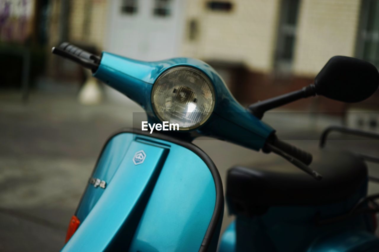 Close-up of cropped scooter on blurred road