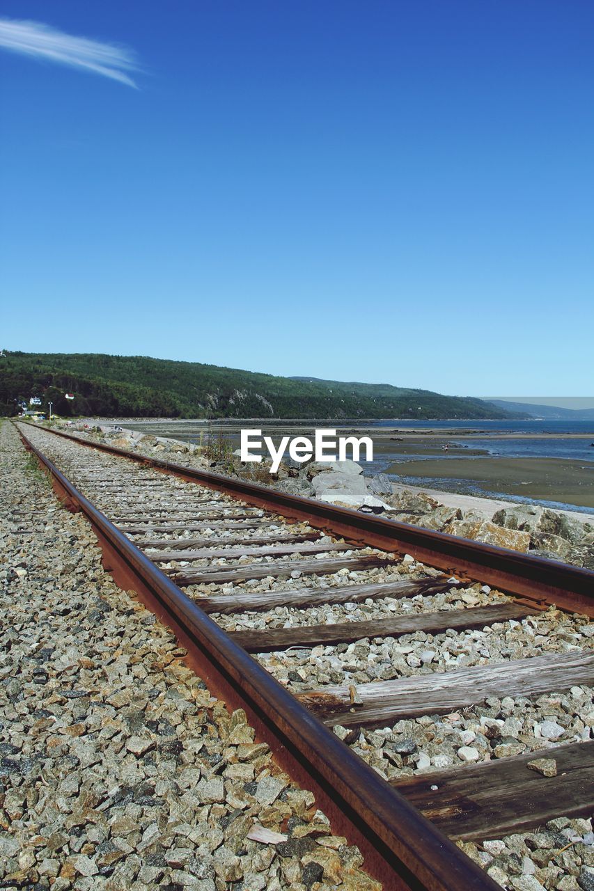 View of railroad track by sea against clear sky