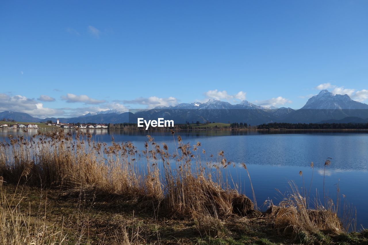 Scenic view of lake by mountains against sky