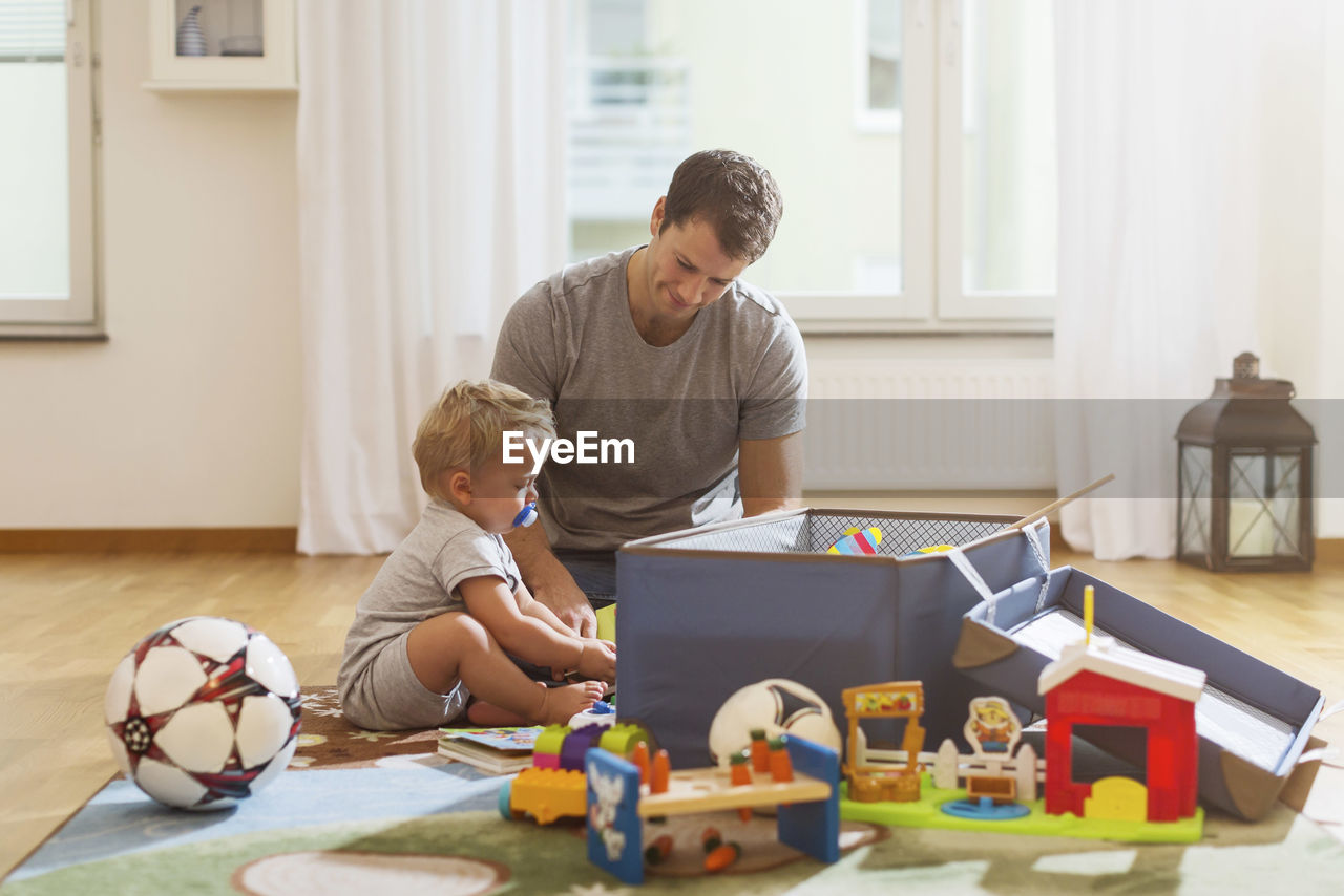 Father and baby boy playing with toys at home