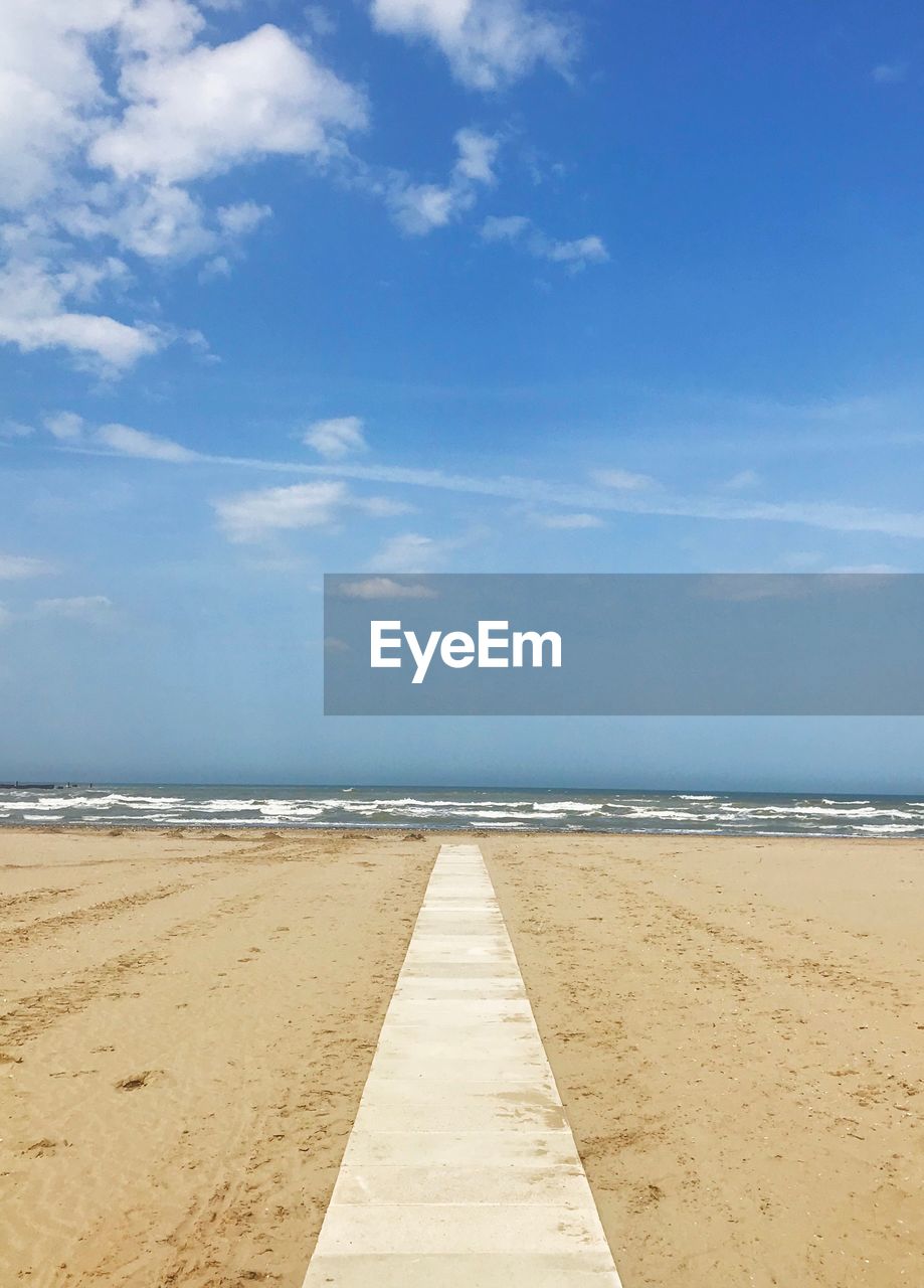 Scenic view of beach against blue sky