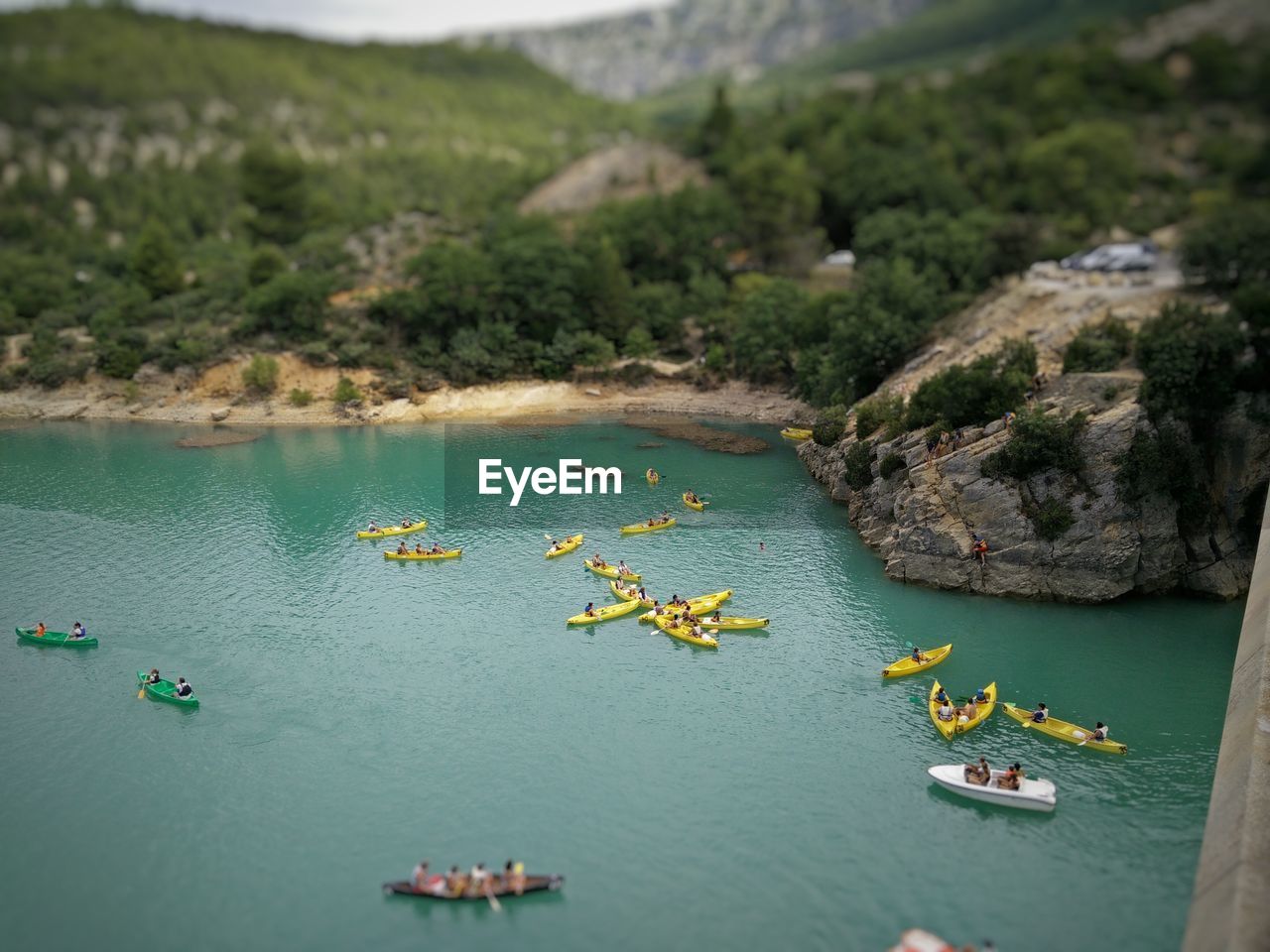 Tilt-shift image of people rowing boats in river