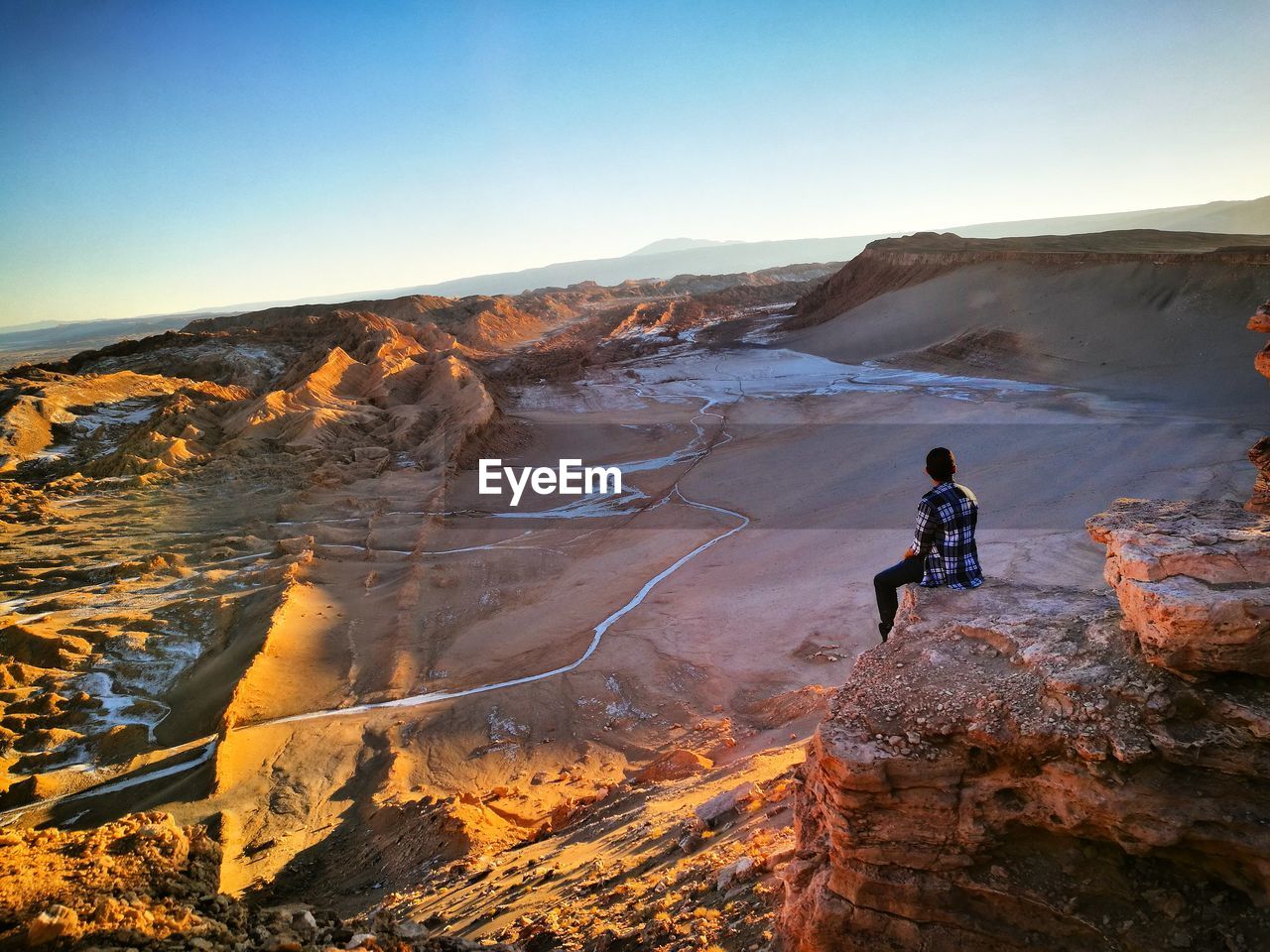 Man sitting on rock formation at valle de la luna