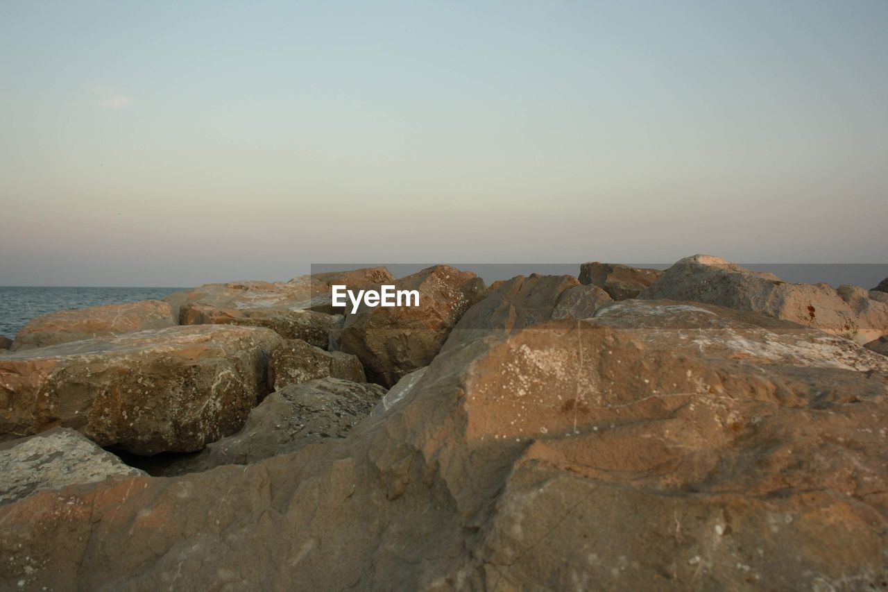 ROCKS ON SEA SHORE AGAINST SKY