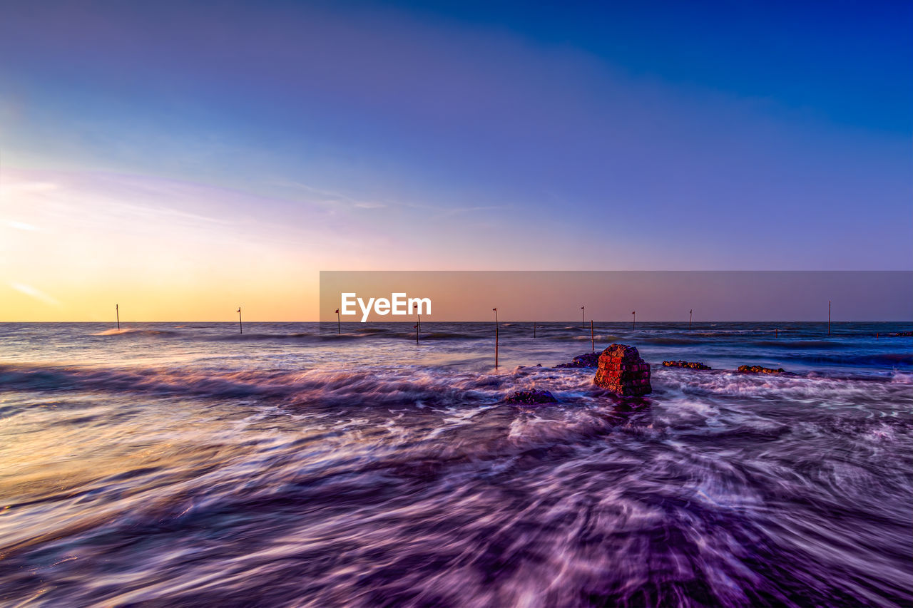 SCENIC VIEW OF BEACH DURING SUNSET