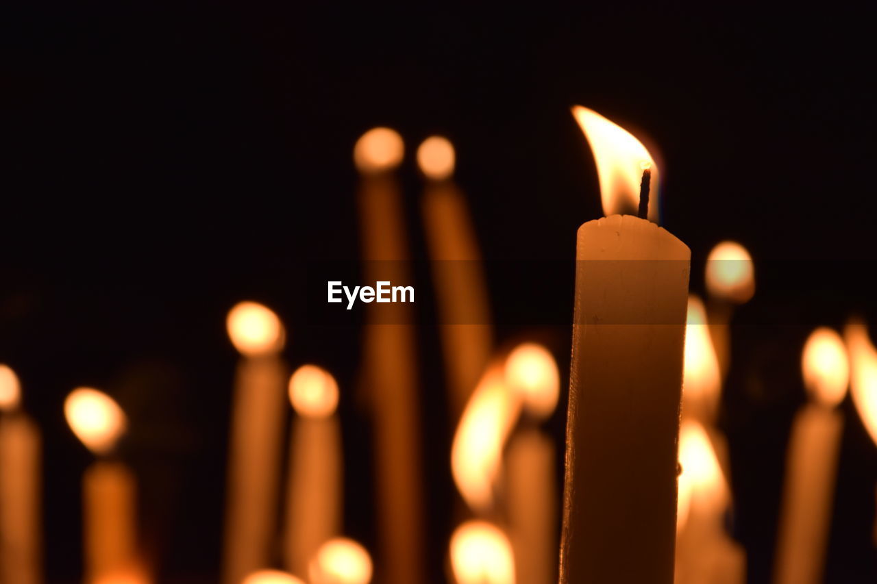 Close-up of lit candle in dark room