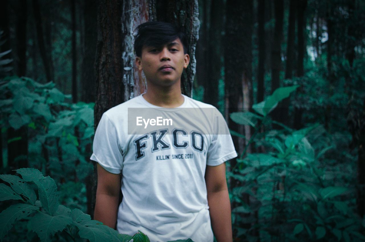 PORTRAIT OF YOUNG MAN LOOKING AT FOREST