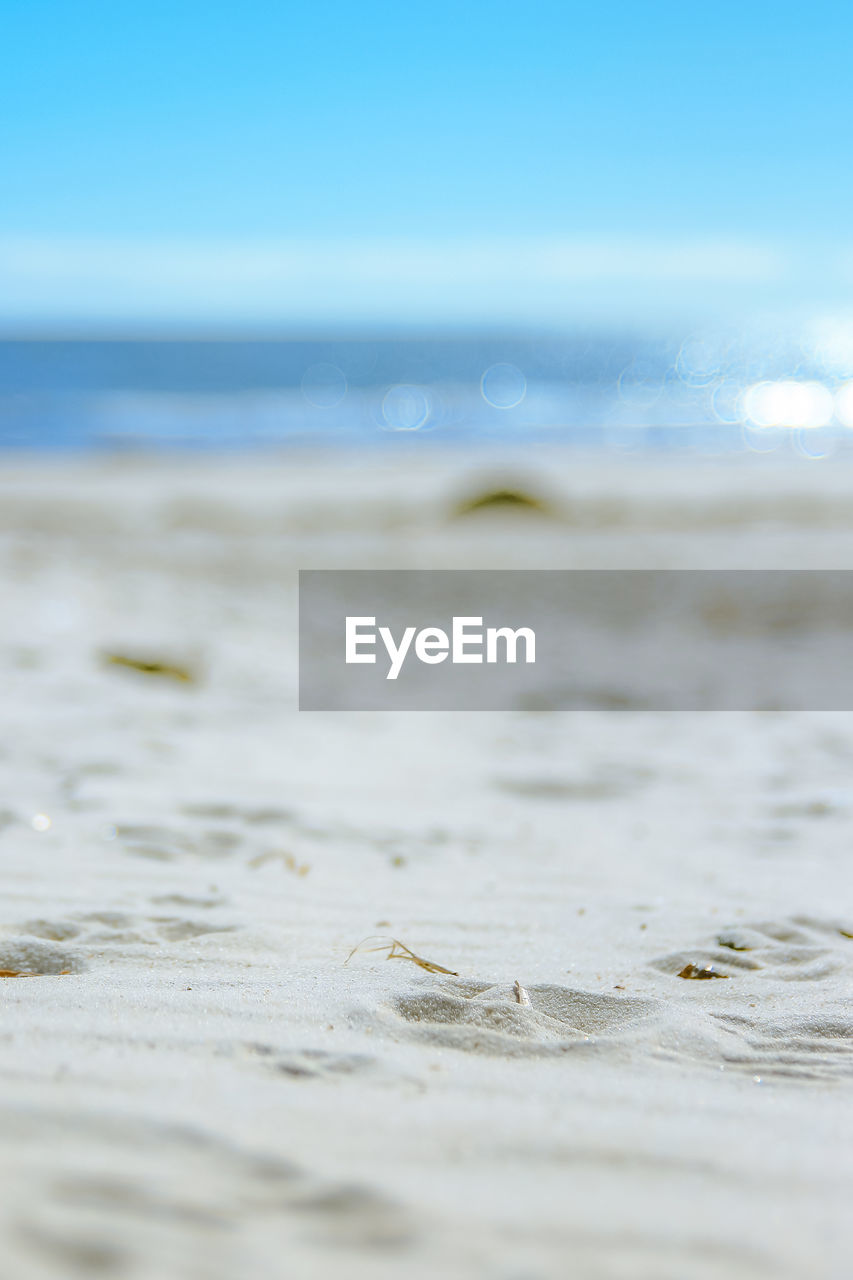 Close-up of sand at beach against sky