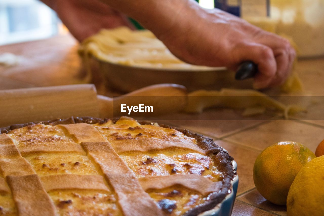 Cropped image of person preparing pie in kitchen