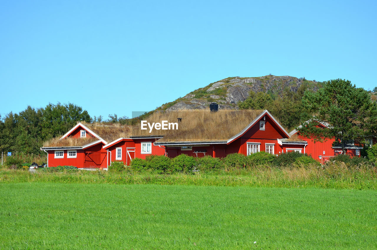 HOUSE ON FIELD AGAINST SKY