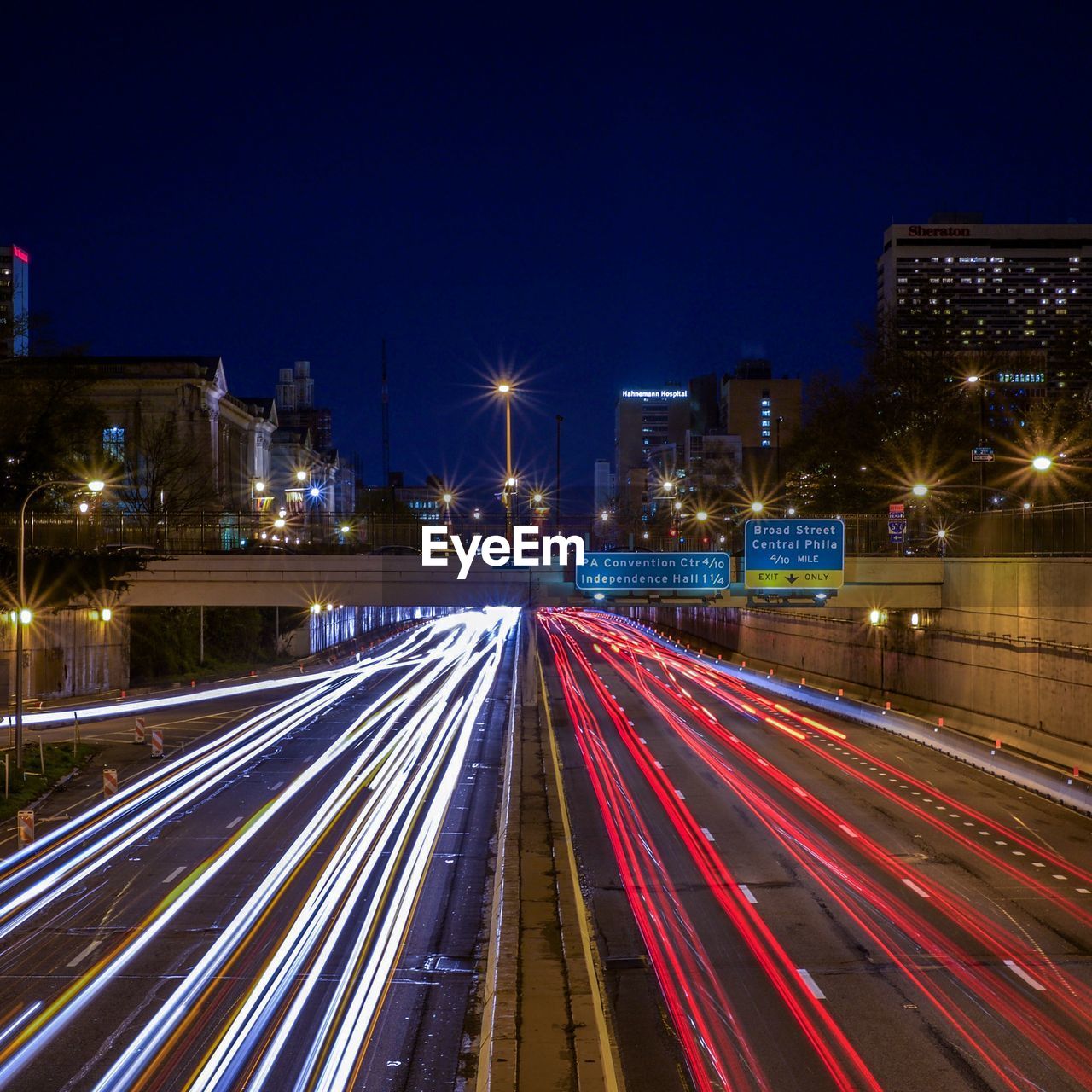 Light trail on highway in city against sky