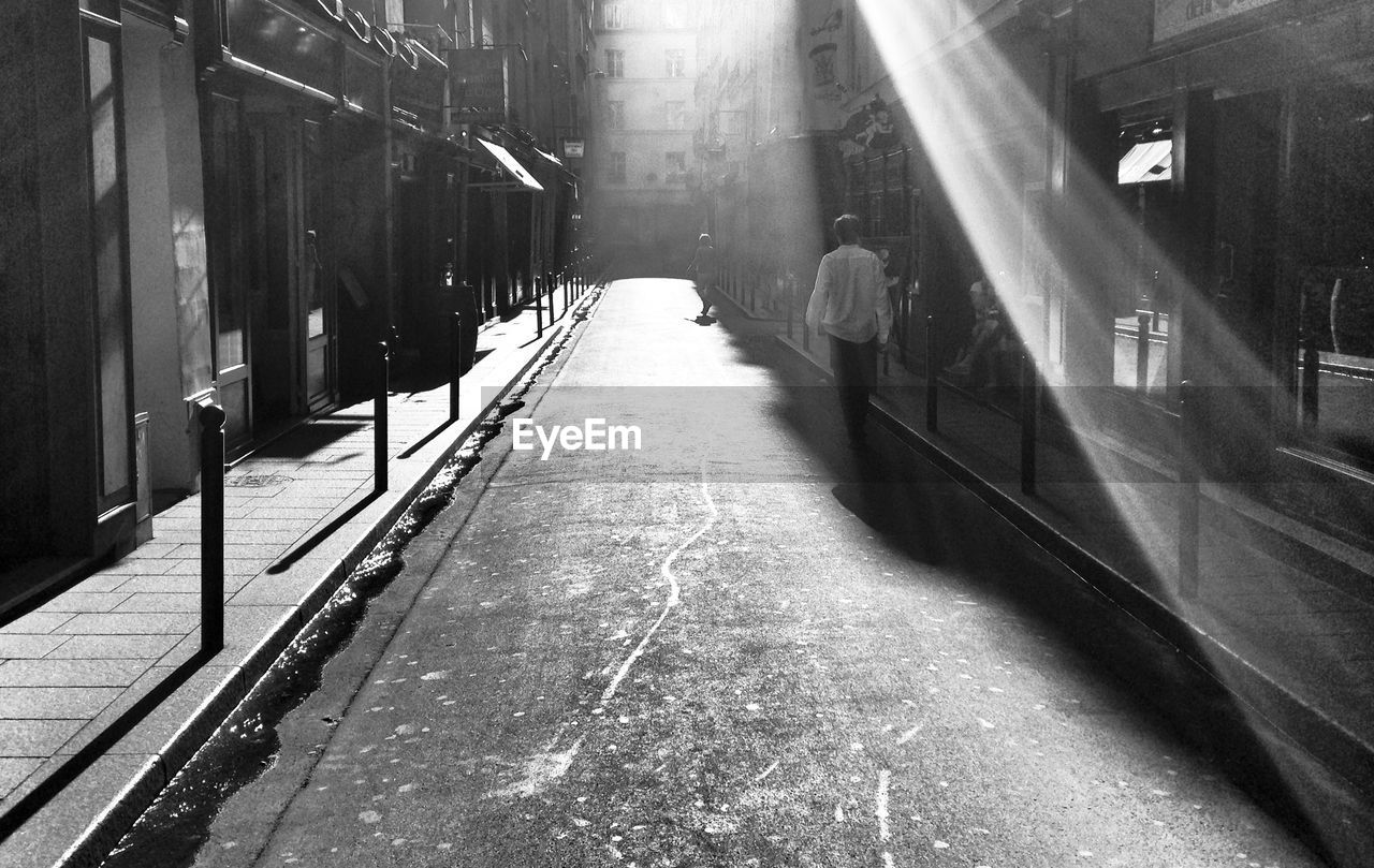 Rear view of man walking on street in city