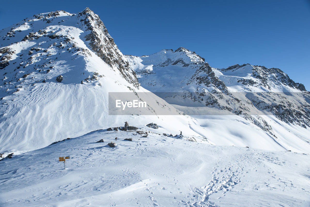 Scenic view of snowcapped mountains against clear sky