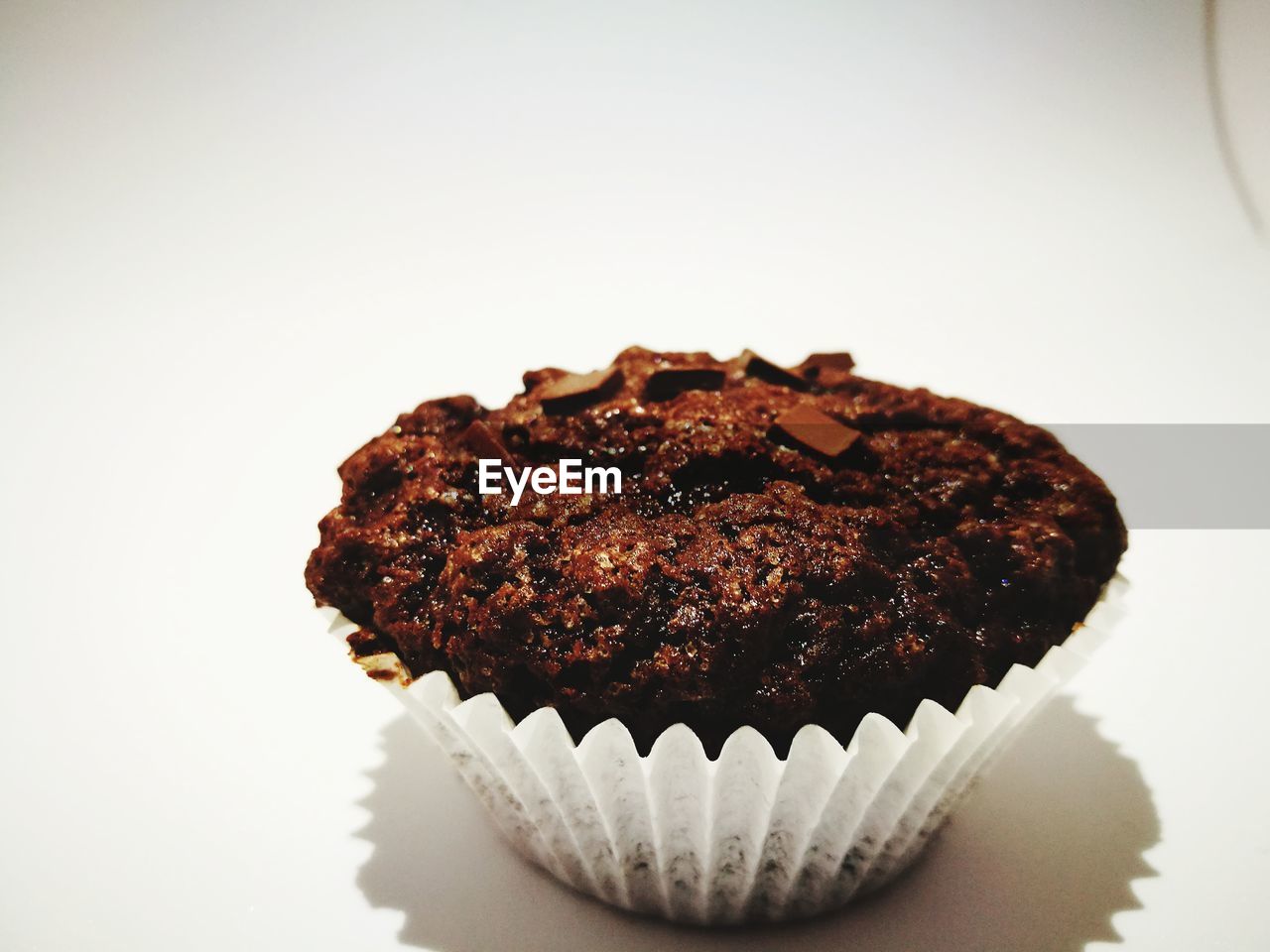 CLOSE-UP OF CHOCOLATE CAKE ON WHITE BACKGROUND