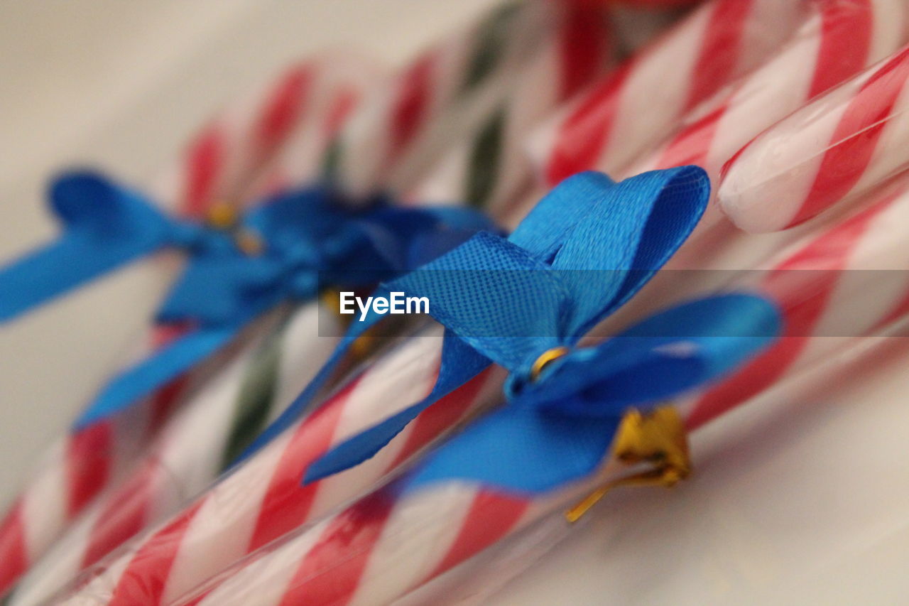 Close-up of blue ribbon tied on candy canes