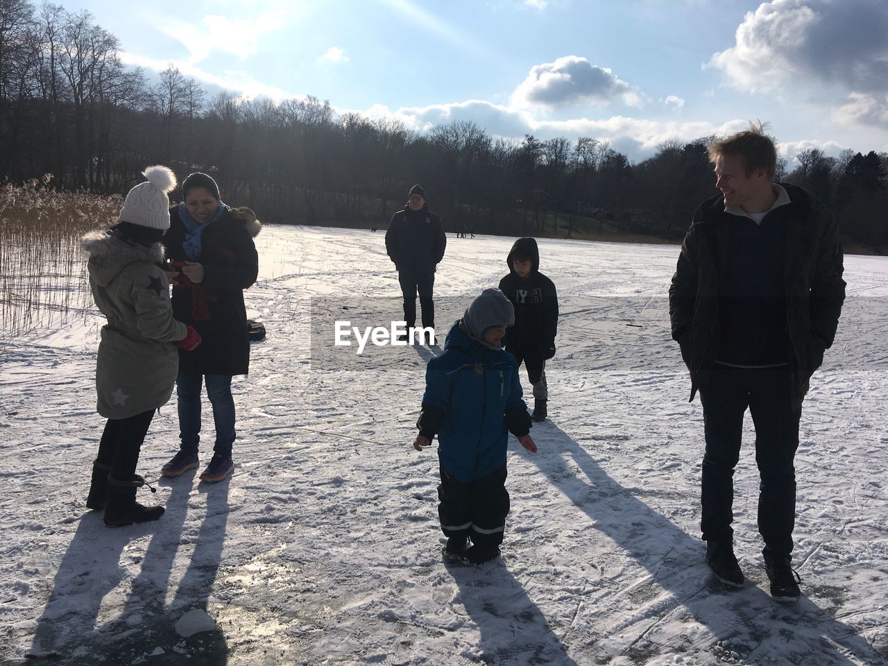 REAR VIEW OF PEOPLE WITH CHILDREN STANDING AT WINTER