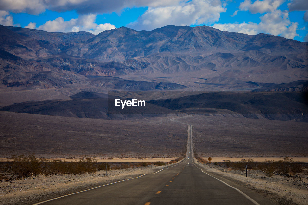 Empty road leading towards mountains