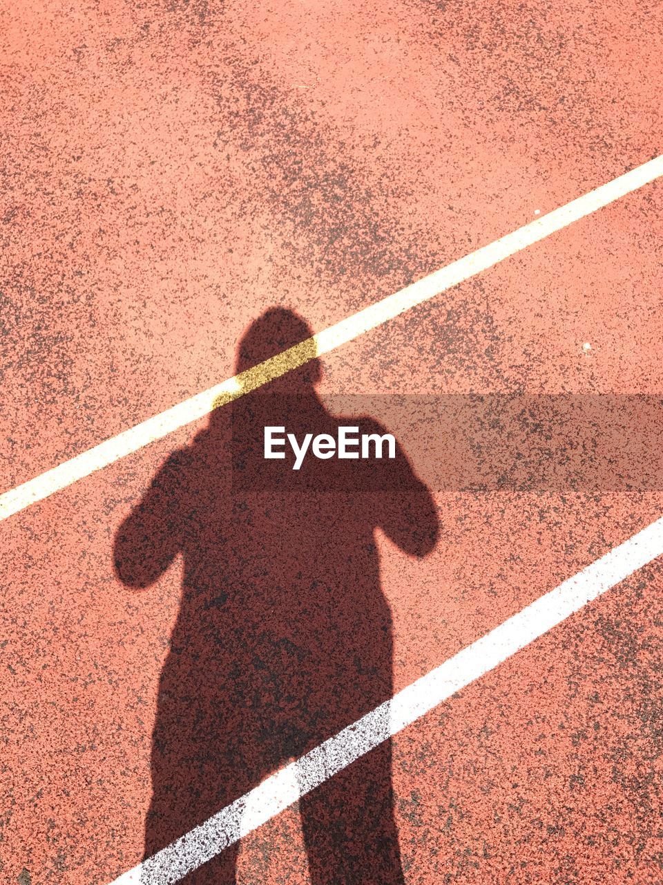 Shadow of man on sports track