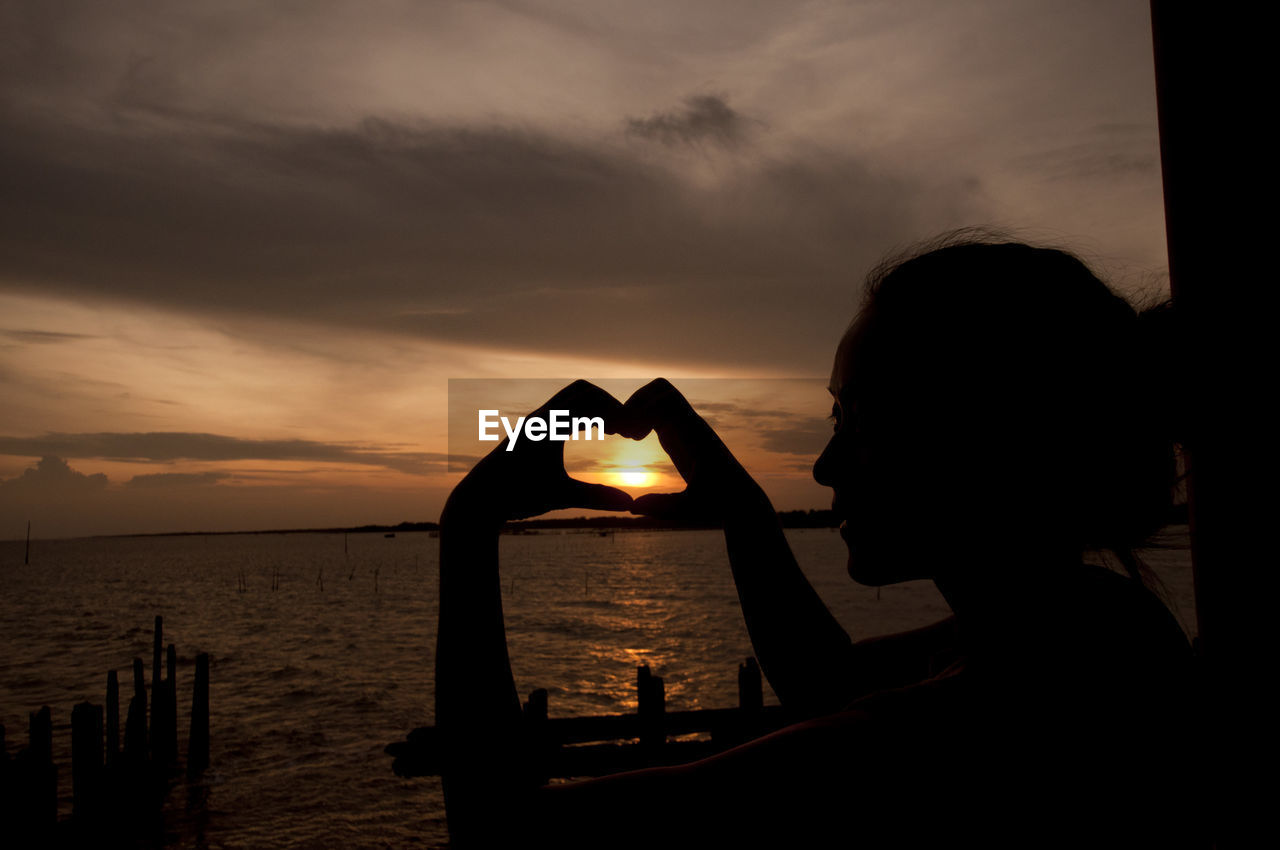 Scenic view of person at sea during sunset