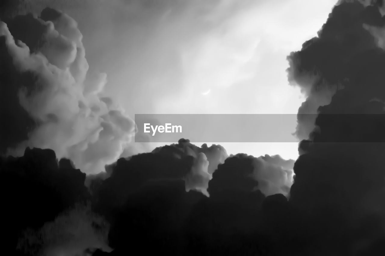 LOW ANGLE VIEW OF STORM CLOUDS OVER SILHOUETTE ROCKS