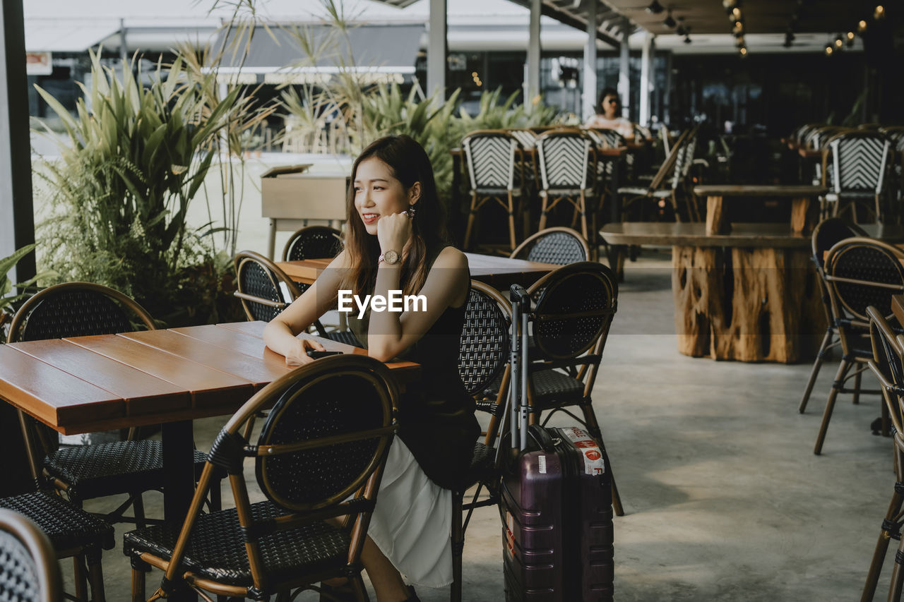 Beautiful woman looking away while sitting at cafe