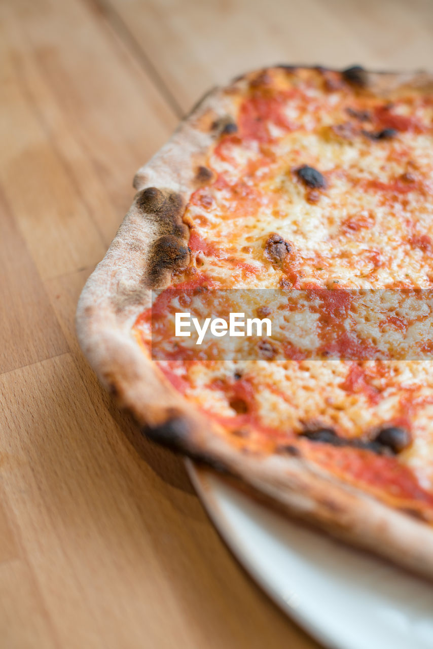 CLOSE-UP OF PIZZA IN PLATE ON TABLE