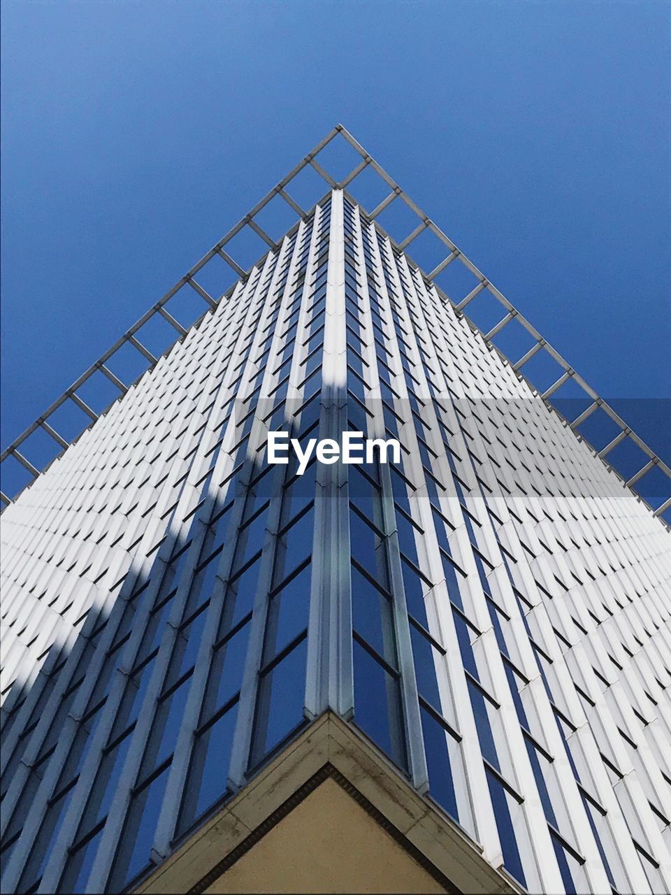 Low angle view of modern building against clear blue sky