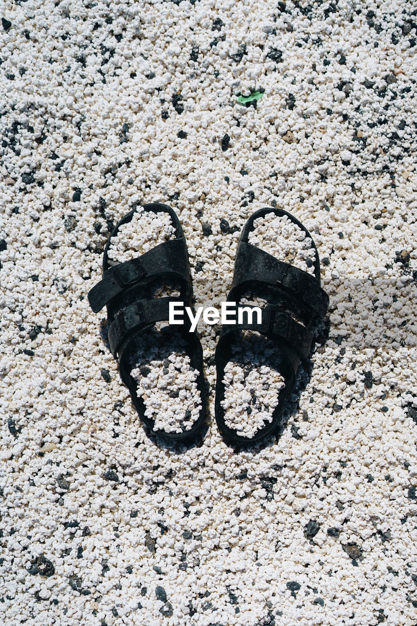 CLOSE-UP OF SHOES ON SAND