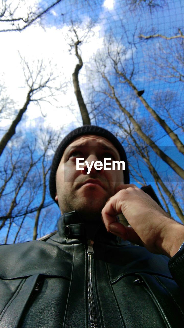 Low angle view of man standing against trees