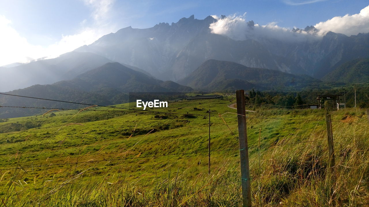 Scenic view of field against cloudy sky