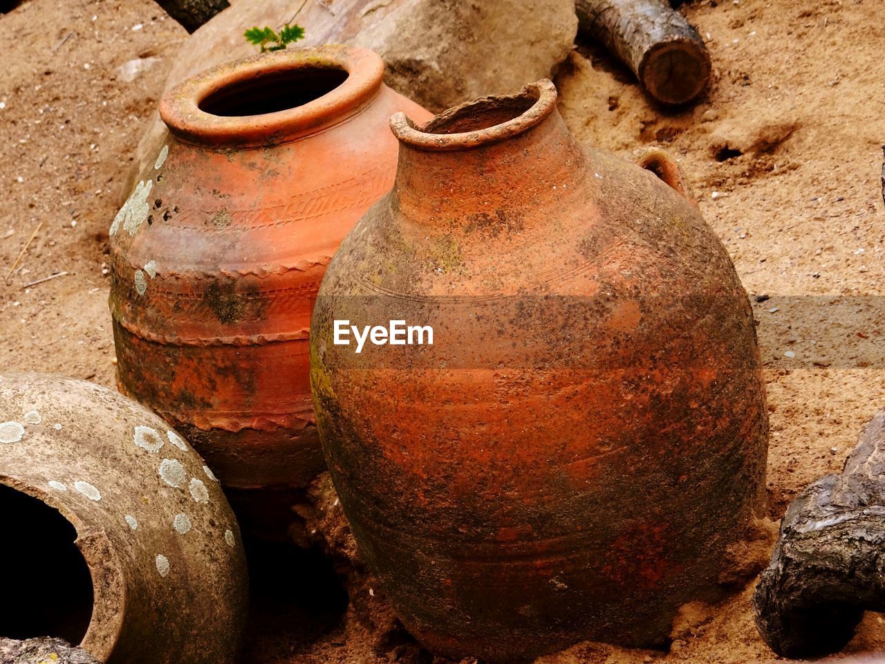 Close-up of abandoned clay pots on field
