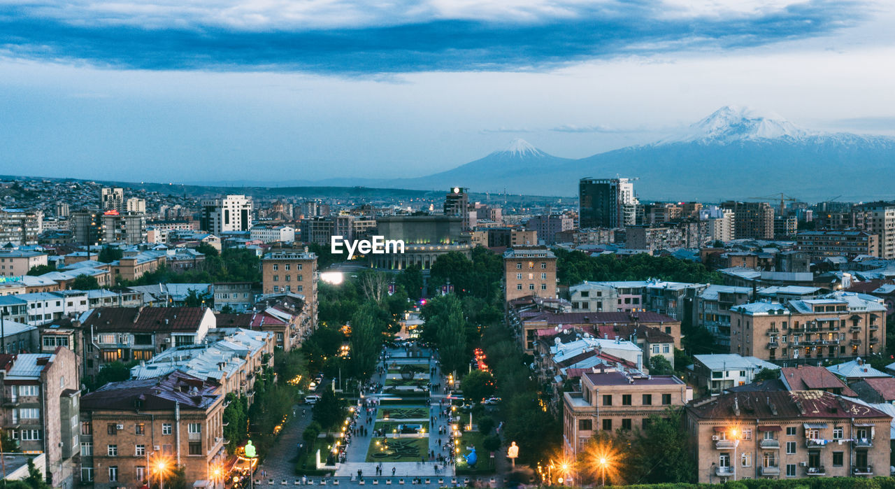 High angle view of illuminated buildings against sky at dusk