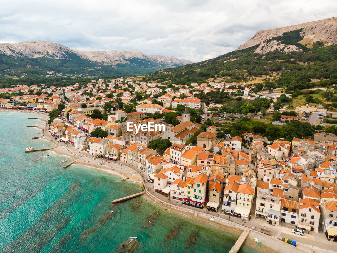 HIGH ANGLE VIEW OF TOWNSCAPE AND SEA AGAINST SKY