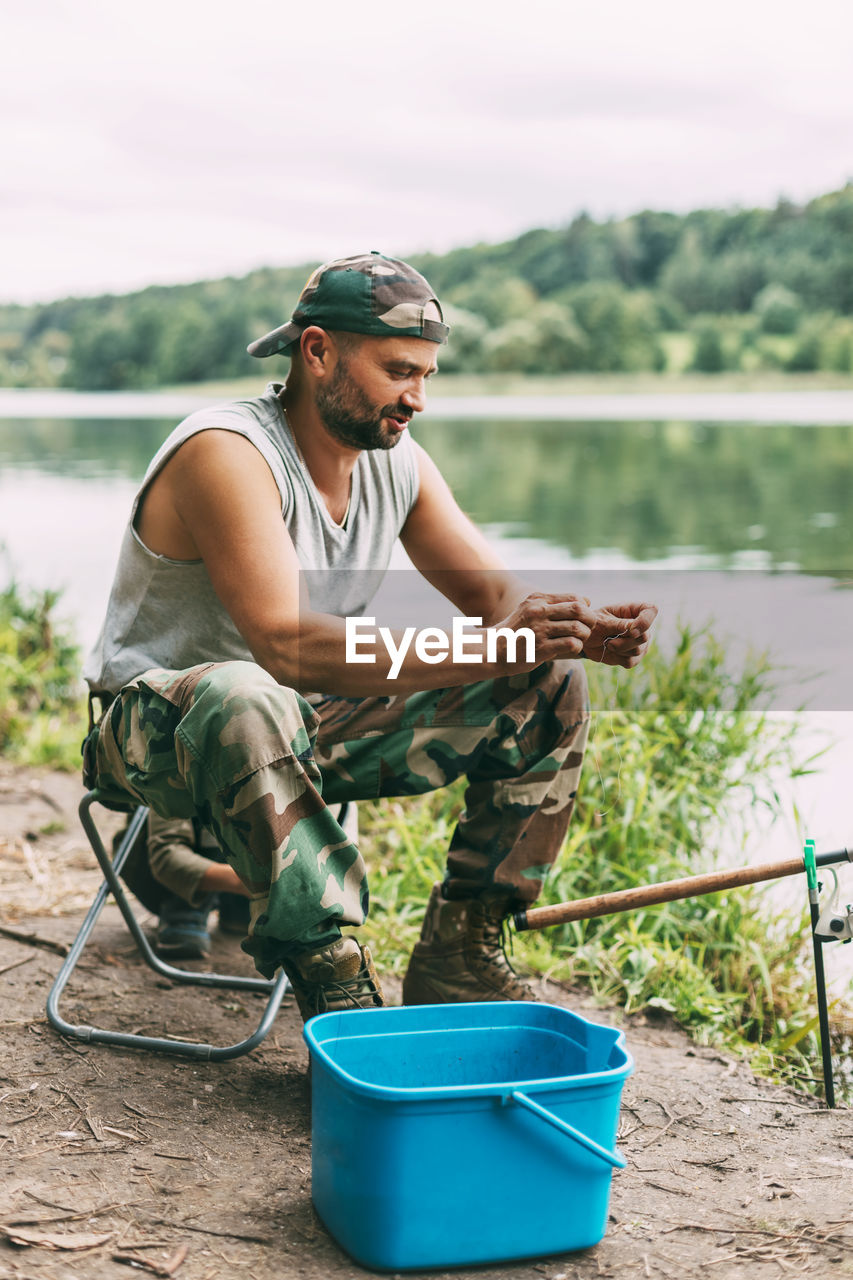 A young fisherman catches fish on a lake or river, prepares tackle and bait. hobbies, weekends