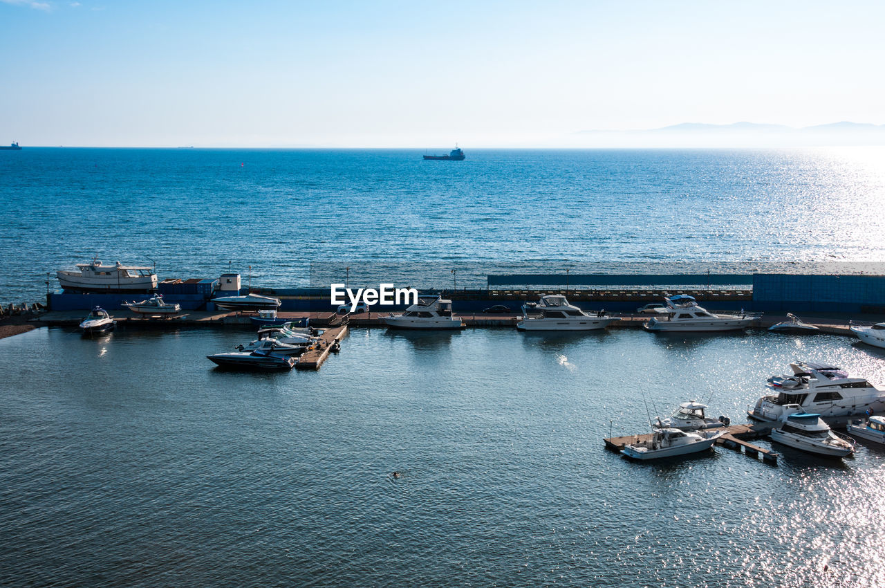 HIGH ANGLE VIEW OF BOATS ON SEA AGAINST CLEAR SKY