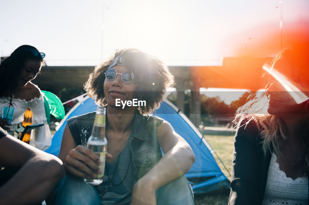 Man drinking alcohol while sitting with friends during event