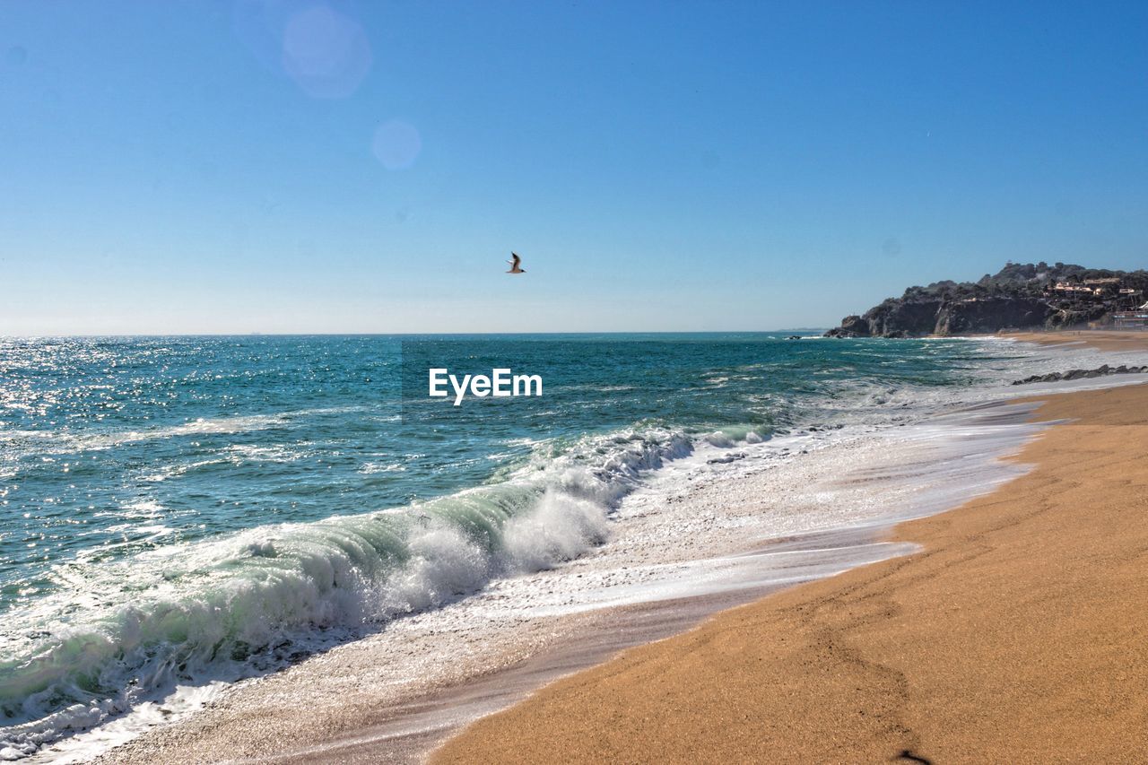 Scenic view of sea against clear blue sky