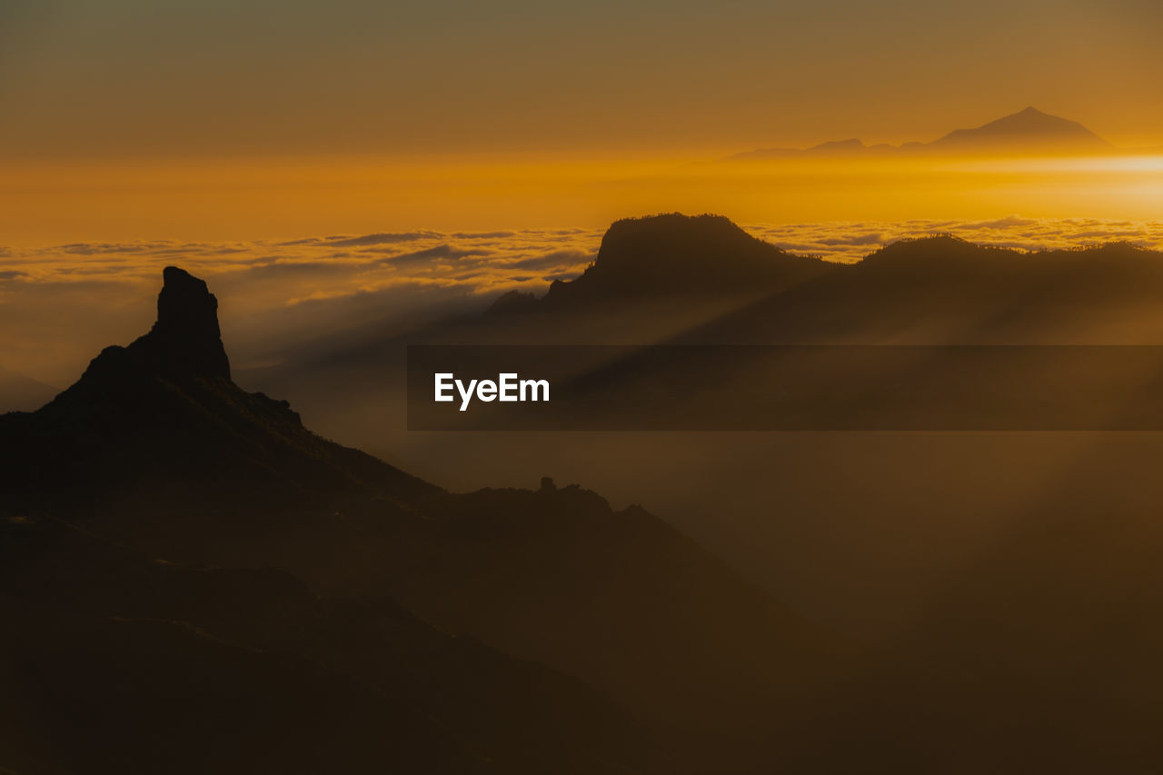 Scenic view of silhouette mountains against sky during sunset