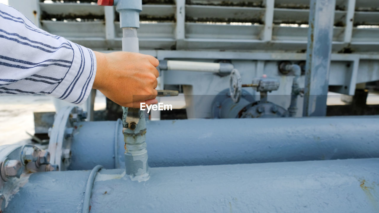 Cropped hand of man holding valve