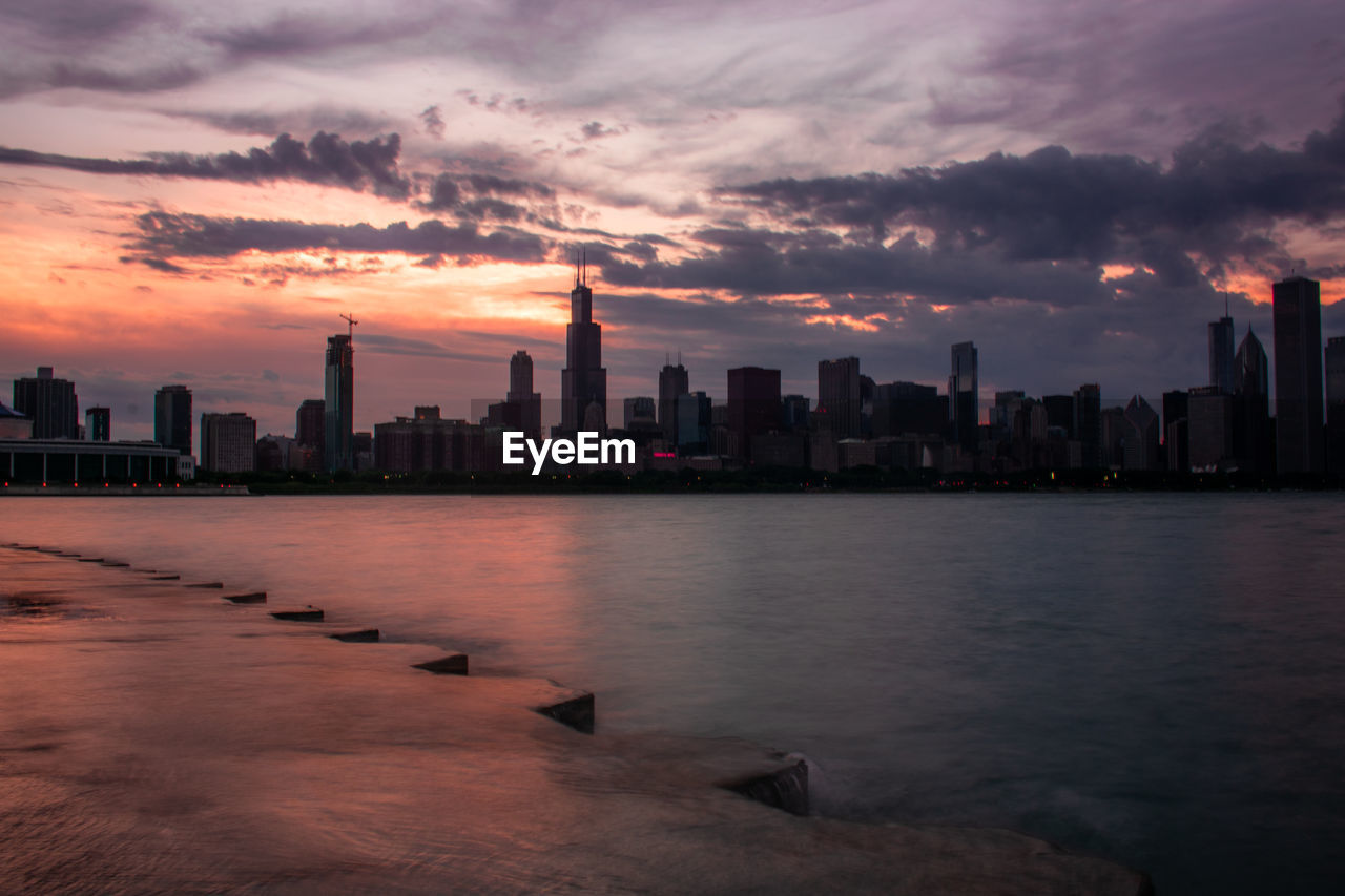 SCENIC VIEW OF BUILDINGS AGAINST SKY AT SUNSET