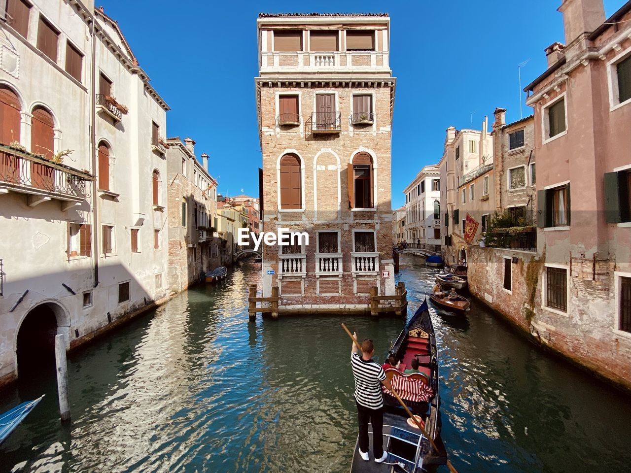 Canal amidst buildings in city against sky