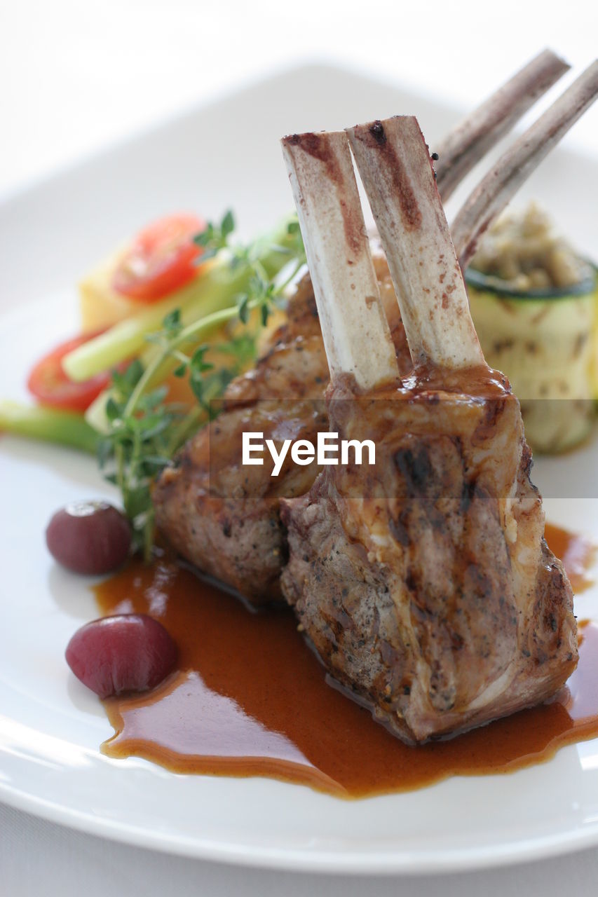 Close-up of meat served in plate against white background