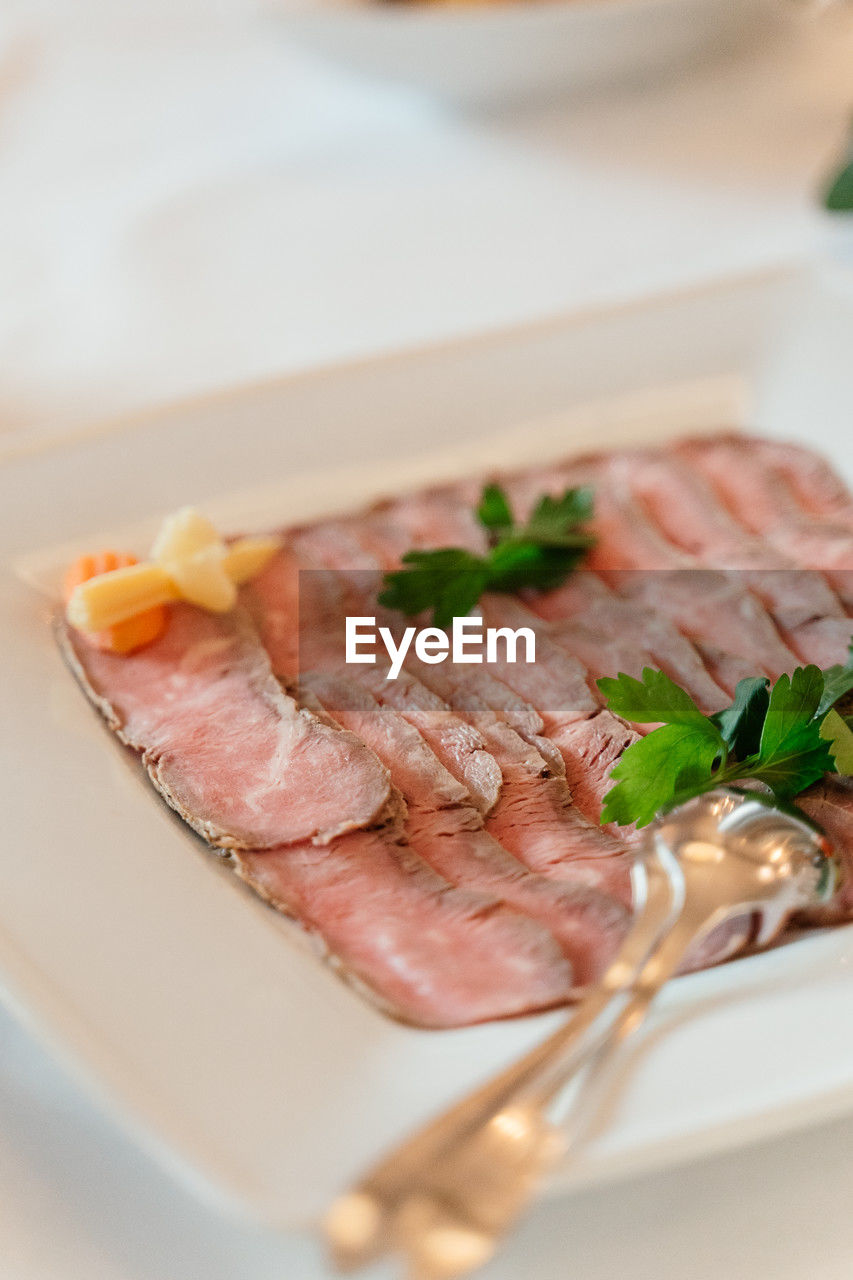 food and drink, food, meat, prosciutto, dish, herb, freshness, healthy eating, plate, meal, no people, selective focus, indoors, pork, close-up, vegetable, processed meat, cuisine, plant, wellbeing, seafood, table, dinner, produce, ham, crockery