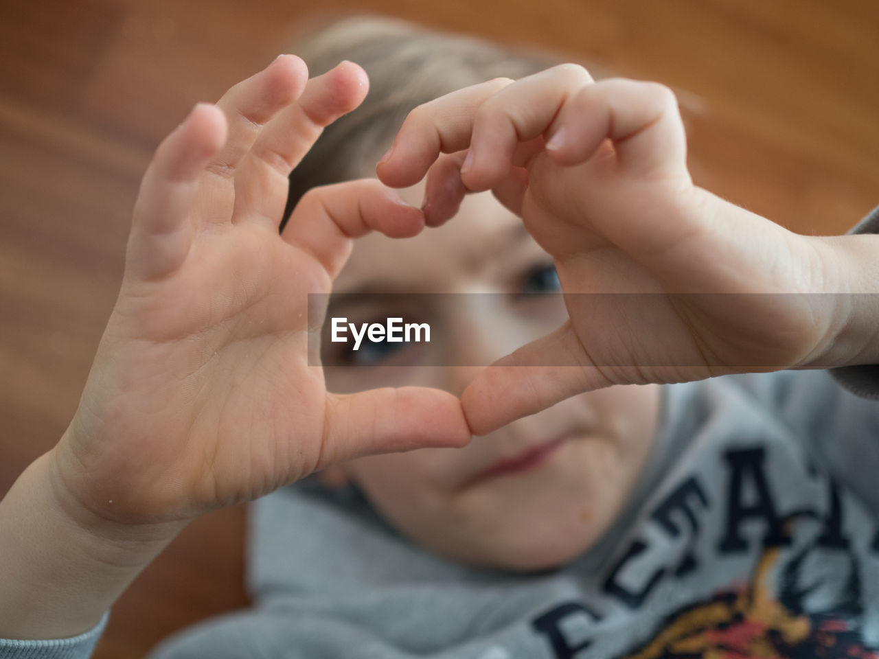 Close-up of boy forming heart shape with hands