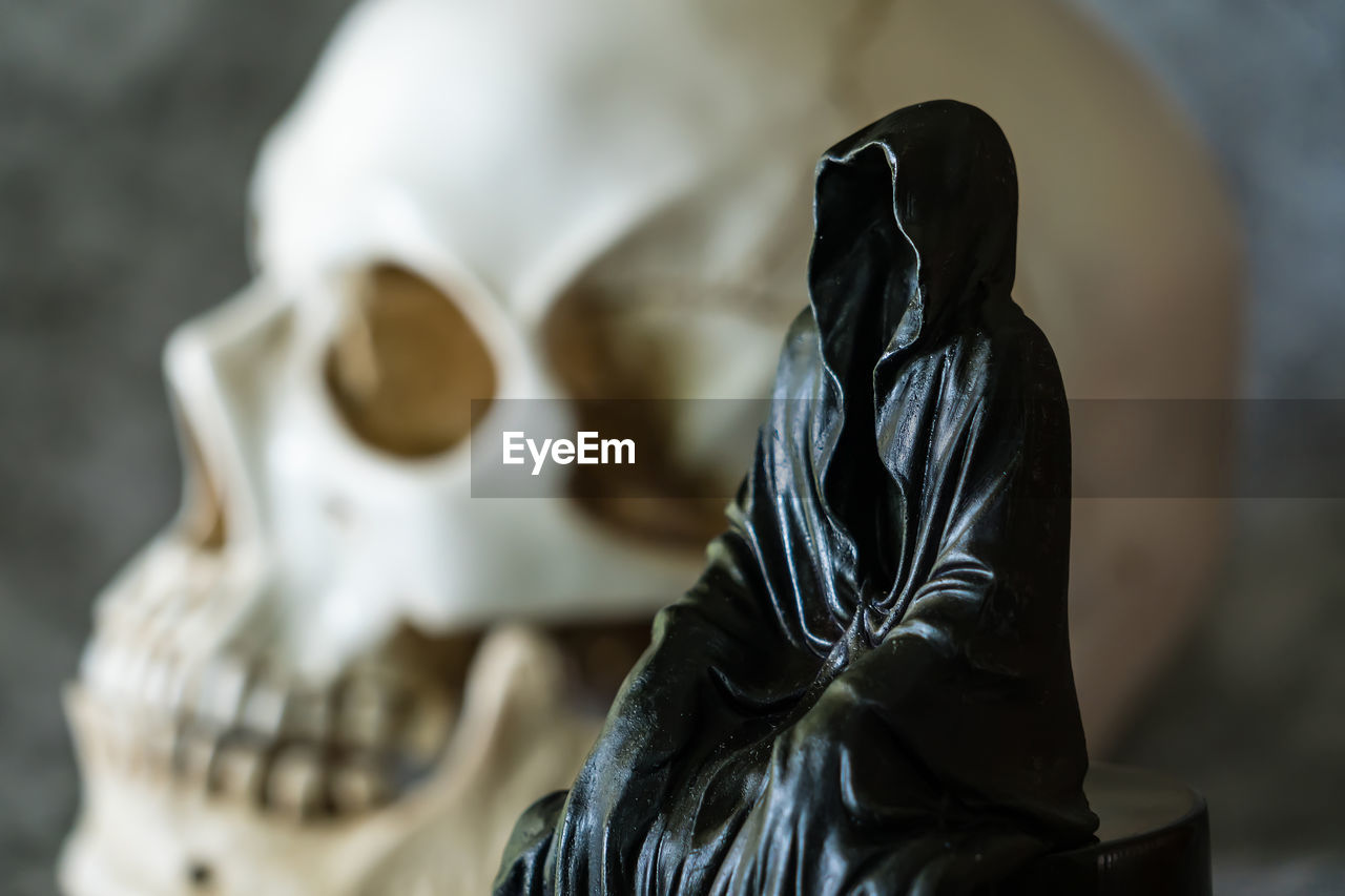 sculpture, statue, death, art, bone, human skeleton, black, indoors, adult, human representation, monument, clothing, one person, focus on foreground, representation, mask