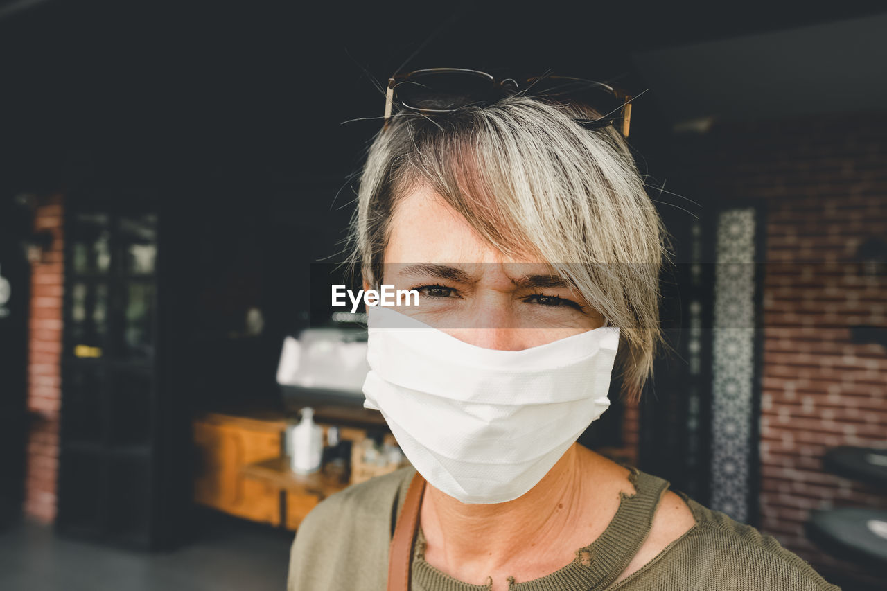 Blonde woman wearing face mask during pandemic time. portrait of an adult woman with mask.