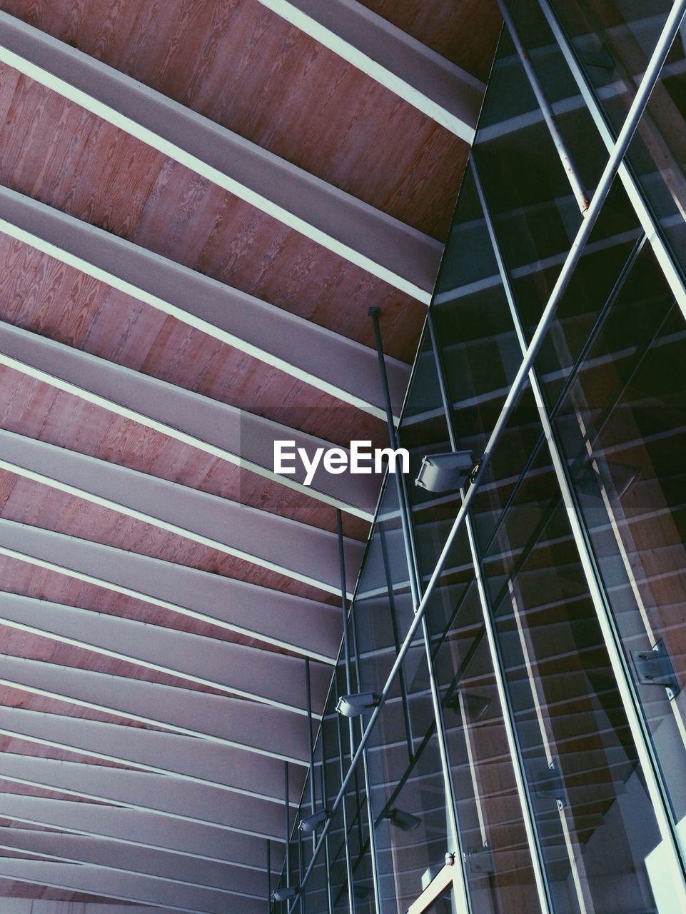 Low angle view of glass window against ceiling of building