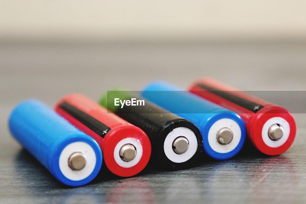 Close-up of colorful batteries on wooden table